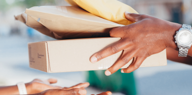 a person delivering three different sized packages to another person