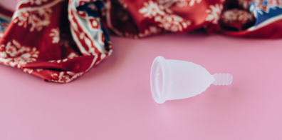 Coupe menstruelle sur une surface rose 